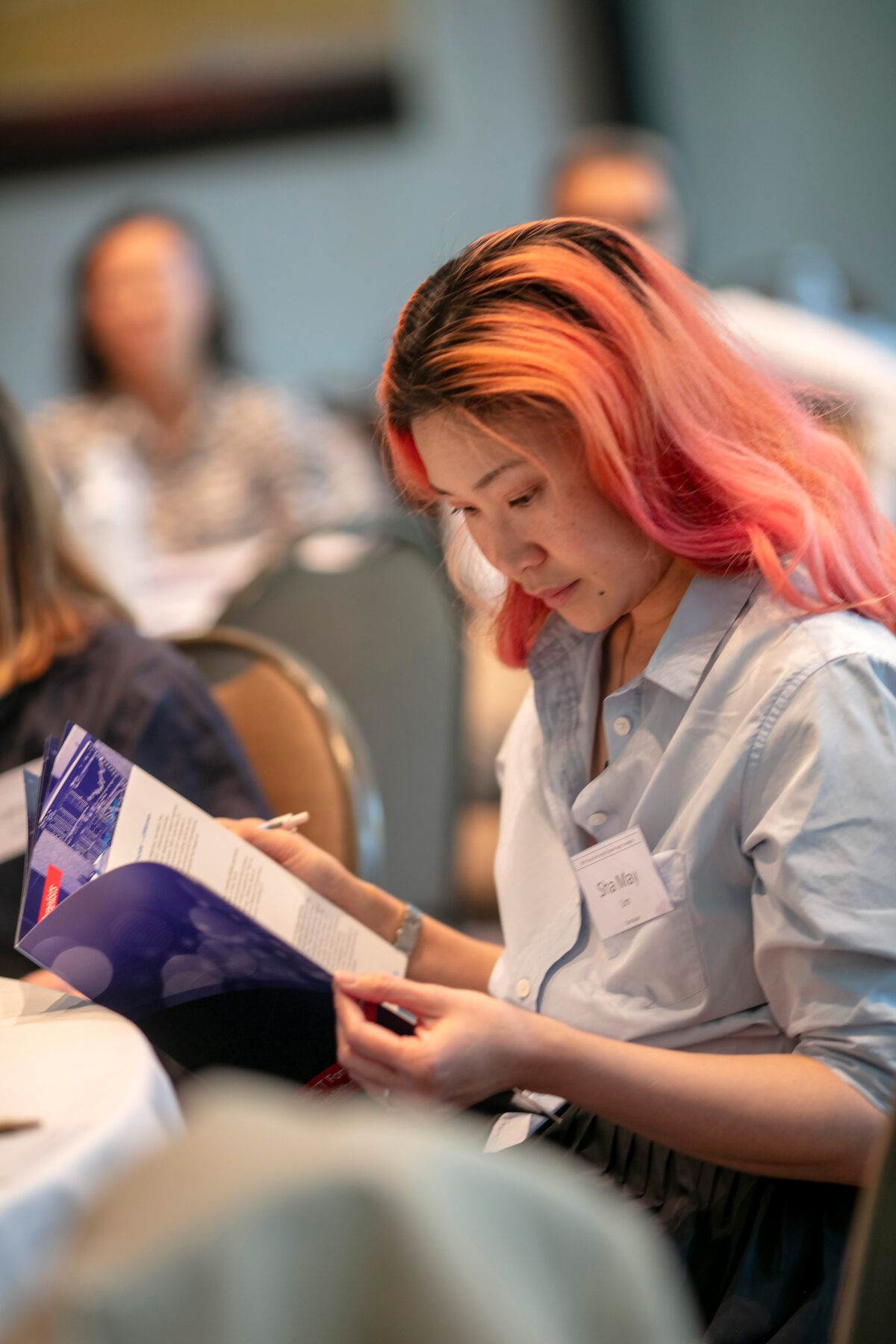 A participant reading the Melbourne Forum brochure